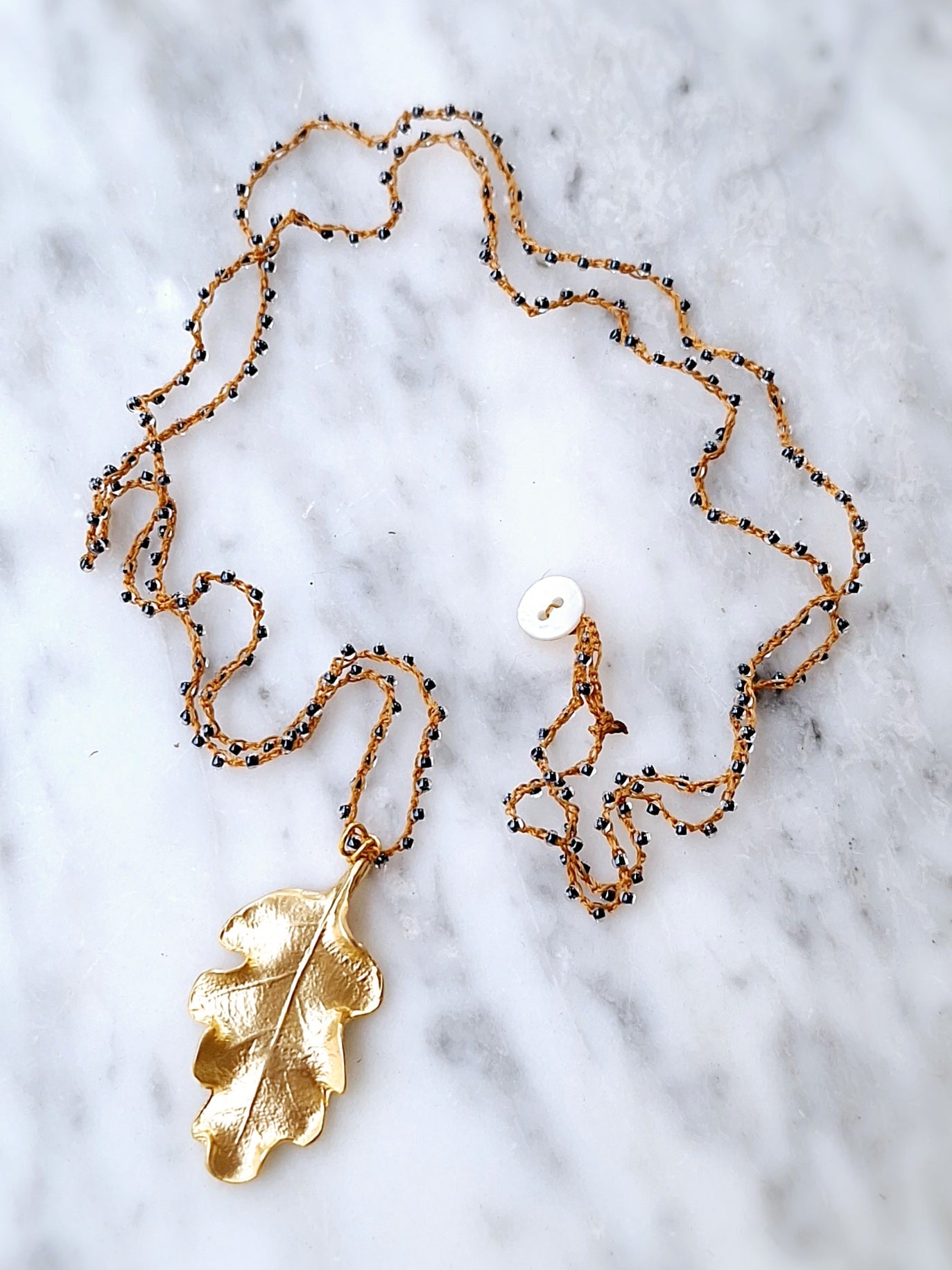 Crochet long necklace with gold plated oak leaf pendant